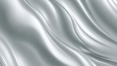 The primary subject of the image is a white sheet of fabric, which is the main object, scene, or focus of the image. The setting or background is a gray surface, which provides a contrasting backdrop for the fabric. The visual style of the image is a close-up of the fabric, showcasing its texture and details. The colors and mood of the image are predominantly white, giving it a clean and minimalist appearance.