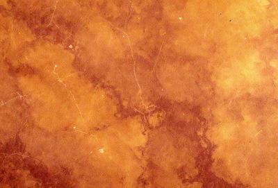 The primary subject of the image is a close-up of a maroon-colored surface, possibly a wall or a piece of furniture. The setting appears to be a room with a brown and white color scheme. The visual style of the image is a close-up, which emphasizes the details of the surface. The colors and mood of the image are warm and inviting, with the maroon color evoking a sense of comfort and relaxation.
