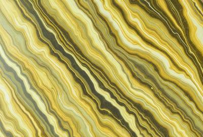 The primary subject of the image is a close-up of a marble tile with a yellow and green color scheme. The setting is a wall, and the visual style is a photo. The colors and mood of the image are warm and inviting, with the yellow and green tones creating a sense of natural beauty.