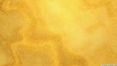 The primary subject of the image is a yellow background with a gold-like texture. The setting is a yellow wall, and the visual style is a close-up of the yellow wall. The colors and mood of the image are warm and inviting, with the yellow and gold tones creating a sense of warmth and comfort.