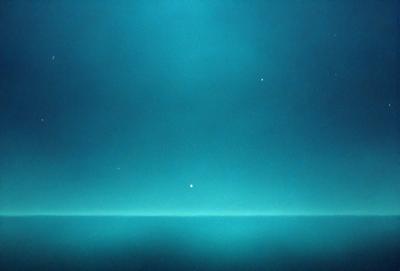 The primary subject of the image is a blue sky with a few stars visible. The setting is a dark blue background, which creates a contrasting effect with the stars. The visual style appears to be a photo, as it captures the night sky with the stars. The colors and mood of the image are predominantly dark and serene, with the blue sky and stars creating a sense of tranquility and wonder.