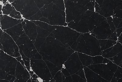The primary subject of the image is a black marble countertop with a white pattern. The setting is a kitchen, and the visual style is a close-up of the marble countertop. The dominant colors are black and white, creating a sleek and modern atmosphere.