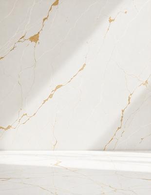 The primary subject of the image is a white marble wall with a gold-colored pattern. The setting is a room with a white surface, and the visual style is a photo. The dominant colors are white and gold, creating a clean and elegant atmosphere.
