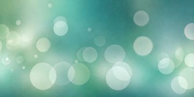 The primary subject of the image is a blue background with a pattern of white circles. The setting is a green and blue ocean, creating a serene and calming atmosphere. The visual style is a combination of a photo and digital art, as the circles have a slightly digital appearance. The colors and mood of the image are predominantly blue and green, with the white circles adding a touch of brightness and contrast.
