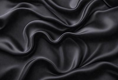 The primary subject of the image is a close-up of a black fabric, possibly a piece of clothing or a curtain. The setting is a dark background, which emphasizes the fabric's texture and pattern. The visual style is a black and white photo, giving the image a classic and timeless appearance. The colors and mood are predominantly dark and moody, with the black fabric serving as the focal point of the image.