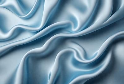 The primary subject of the image is a blue fabric, which appears to be a piece of silk. The setting is a white background, which provides a clean and minimalist appearance. The visual style is a close-up of the fabric, showcasing its texture and details. The colors and mood of the image are predominantly blue, creating a calm and serene atmosphere.