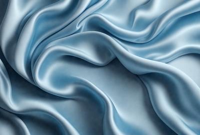 The primary subject of the image is a blue fabric, which appears to be a piece of silk. The setting is a blue background, which complements the blue fabric. The visual style is a close-up of the fabric, showcasing its texture and details. The colors and mood of the image are predominantly blue, creating a calm and serene atmosphere.