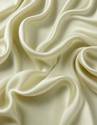 The primary subject of the image is a white fabric, which appears to be a piece of silk. The setting is a white background, which creates a clean and minimalist appearance. The visual style is a close-up of the fabric, showcasing its texture and details. The colors and mood of the image are predominantly white, giving it a calm and serene atmosphere.