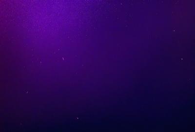 The image features a purple background with a few stars scattered throughout the scene. The primary subject is the night sky, which appears to be a digital art or illustration. The visual style gives the impression of a futuristic or space-themed setting. The colors and mood of the image are predominantly purple, creating a calm and serene atmosphere.
