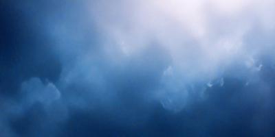 The primary subject of the image is a cloudy sky. The setting is a blue sky with clouds, creating a dramatic and moody atmosphere. The visual style is a photo, capturing the beauty of the cloudy sky. The colors and mood are predominantly blue, with the clouds adding depth and contrast to the scene.