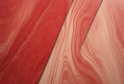 The primary subject of the image is a wooden surface with a red and brown color scheme. The setting is a room with a wooden floor, and the visual style is a close-up of the wooden surface. The colors and mood of the image are warm and inviting, with the red and brown tones creating a sense of warmth and comfort.