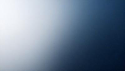 The primary subject of the image is a blue sky with a few clouds. The setting is a clear day with a cloudy sky. The visual style is a photo, and the colors and mood are predominantly blue, creating a calm and serene atmosphere.