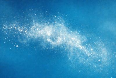 The primary subject of the image is a blue sky filled with white stars. The setting is a clear, cloudless sky, and the visual style is a digital art or illustration. The colors and mood of the image are predominantly blue and serene, creating a peaceful and tranquil atmosphere.