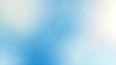 The primary subject of the image is a blue sky with clouds. The setting is a cloudy day, and the visual style is a natural, outdoor scene. The colors and mood of the image are predominantly blue and calm, creating a serene atmosphere.