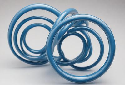 The primary subject of the image is a pair of blue rubber rings. The setting is a white background, and the visual style is a photo. The dominant colors are blue and white, creating a clean and modern atmosphere.