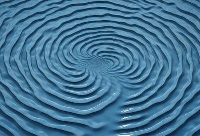 The primary subject of the image is a blue swirling vortex, which appears to be a part of a larger body of water. The setting is a blue ocean, and the visual style is a photo. The dominant colors in the image are blue and white, creating a serene and calming atmosphere.