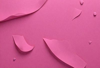 The primary subject of the image is a pink background with a pattern of pink and white paper cutouts. The cutouts are shaped like leaves and are scattered across the background. The setting appears to be a creative and artistic environment, possibly for a project or an artistic display. The visual style of the image is a combination of digital art and illustration, as the paper cutouts are carefully crafted and arranged to create a visually appealing pattern. The colors and mood of the image are predominantly p