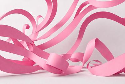 The primary subject of the image is a pink ribbon. The ribbon is wound up and appears to be in a spiral pattern. The setting is a white background, which provides a clean and simple backdrop for the ribbon. The visual style of the image is a close-up of the pink ribbon, showcasing its texture and pattern. The colors and mood of the image are predominantly pink, creating a warm and feminine atmosphere.