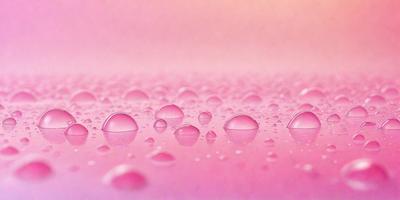 The primary subject of the image is a close-up of a pink surface with a pattern of water droplets on it. The setting is a pink background, and the visual style appears to be a photo. The colors and mood of the image are predominantly pink, creating a warm and inviting atmosphere.