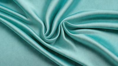 The primary subject of the image is a piece of blue fabric, which is the main object, scene, or focus of the image. The setting or background is a blue cloth, and the visual style is a photo. The dominant colors and overall atmosphere are blue and green, creating a calm and serene mood.