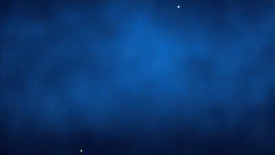 The primary subject of the image is a blue sky with a few stars visible. The setting is a dark blue background, which contrasts with the bright stars. The visual style is a photo, capturing the night sky with the stars as the main focus. The colors and mood of the image are serene and peaceful, as the stars create a sense of calmness and tranquility.