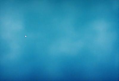 The primary subject of the image is a blue sky with clouds. The setting is a vast, open space with no visible landmarks or objects. The visual style is a natural, outdoor scene. The colors and mood are predominantly blue and serene, creating a peaceful atmosphere.