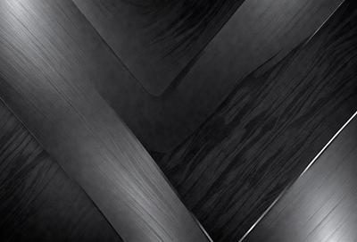 The primary subject of the image is a close-up of a wooden surface, possibly a piece of wood or a wooden wall. The setting is a dark room, which creates a moody atmosphere. The visual style appears to be a black and white photo, giving the image a classic and timeless feel. The dominant colors are black and white, with the wooden surface being the main focus of the image.