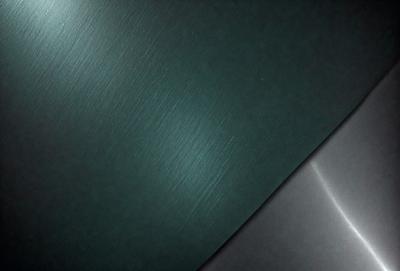 The primary subject of the image is a close-up of a green surface, possibly a piece of fabric or a wall. The setting is a dark room, and the visual style appears to be a photo. The dominant colors in the image are green and black, creating a moody atmosphere.