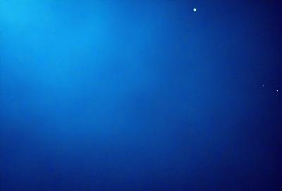 The primary subject of the image is the vast, dark blue sky. The setting is a cloudless night, with no visible landmarks or objects. The visual style is a natural, unaltered photograph. The colors and mood convey a sense of tranquility and serenity, as the sky is void of any distractions or light sources.
