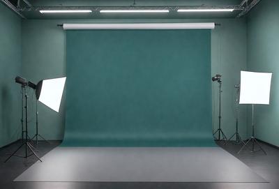 The primary subject of the image is a large green screen, which is the main object in the scene. The setting is a studio, with a backdrop of a green wall. The visual style is a photo, capturing the screen and its surroundings. The colors in the image are predominantly green, creating a calm and soothing atmosphere.