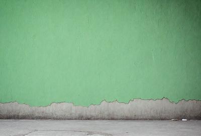 The primary subject of the image is a green wall. The setting is a room with a green wall, and the visual style is a photo. The dominant colors are green, and the overall atmosphere is calm and serene.