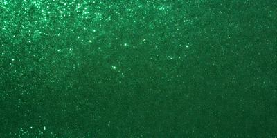 The primary subject of the image is a green background with a pattern of glittering stars. The setting appears to be a dark room, and the visual style is a combination of a photo and digital art. The colors and mood of the image are predominantly green, with a sense of depth and intricacy created by the pattern of stars.