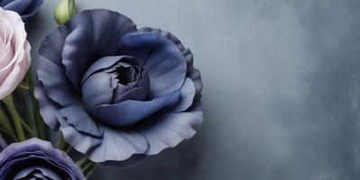 The primary subject of the image is a large, dark blue flower with a purple center. The setting is a blue wall, which serves as the backdrop for the flower. The visual style of the image is a close-up, digital art of the flower. The dominant colors in the image are blue and purple, creating a calm and serene atmosphere.