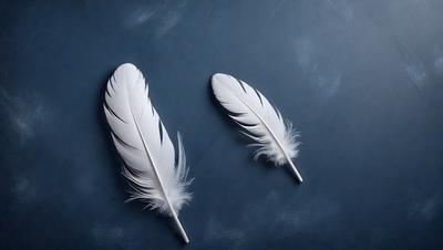 The primary subject of the image is a pair of white feathers, which are the main objects in the scene. The feathers are placed on a blue surface, which serves as the background. The visual style of the image is a close-up of the feathers, showcasing their details and texture. The colors in the image are predominantly blue and white, creating a calm and serene atmosphere.
