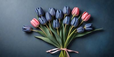 The primary subject of the image is a bouquet of blue and pink tulips. The bouquet is placed on a blue surface, which serves as the setting or background. The visual style of the image is a close-up of the flowers, showcasing their vibrant colors and details. The overall atmosphere of the image is one of beauty and freshness, as the flowers are the main focus and the blue surface adds a touch of elegance to the scene.