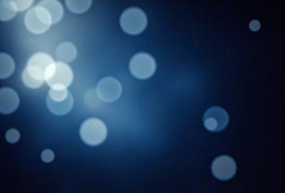 The primary subject of the image is a blue background with a pattern of white lights. The setting appears to be a dark room, and the visual style is a combination of a photo and digital art. The dominant colors are blue and white, creating a calm and serene atmosphere.
