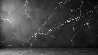 The primary subject of the image is a marble wall with a black background. The setting is a room with a large, gray marble wall that features a pattern of white and black. The visual style is a photo, and the colors and mood are dark and moody.