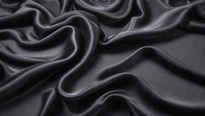 The primary subject of the image is a close-up of a black fabric, possibly a piece of clothing or a curtain. The setting is a dark background, which emphasizes the fabric's texture and pattern. The visual style appears to be a photo, as it captures the details of the fabric. The colors and mood of the image are predominantly dark, with the black fabric being the main focus.