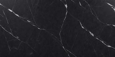 The primary subject of the image is a black marble countertop. The setting is a kitchen, with the countertop being the main focus of the scene. The visual style is a close-up of the marble countertop, showcasing its texture and pattern. The colors and mood of the image are predominantly dark, with the black marble countertop being the main source of contrast.