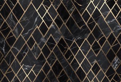 The primary subject of the image is a black and gold marble pattern. The setting is a black and gold marble wall, which serves as the background. The visual style is a close-up of the marble pattern, showcasing the intricate details of the design. The colors and mood of the image are predominantly black and gold, giving it a luxurious and elegant appearance.
