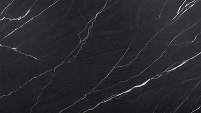 The primary subject of the image is a black marble countertop. The setting is a kitchen, with the countertop being the main focus of the scene. The visual style is a close-up of the marble countertop, showcasing its texture and pattern. The colors and mood of the image are predominantly dark, with the black marble providing a striking contrast against the surrounding environment.