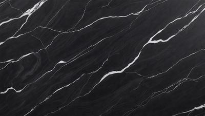 The primary subject of the image is a black marble countertop. The setting is a kitchen, with the countertop being the main focus of the scene. The visual style is a close-up of the marble countertop, showcasing its texture and pattern. The colors and mood of the image are predominantly dark, with the black marble providing a striking contrast against the darker background.
