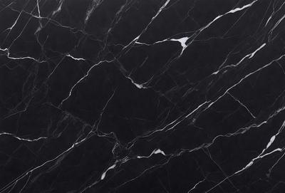 The primary subject of the image is a black marble countertop. The setting is a kitchen, with the countertop being the main focus of the scene. The visual style is a close-up of the marble countertop, showcasing its texture and pattern. The colors and mood of the image are predominantly dark, with the black marble providing a striking contrast against the dark background.