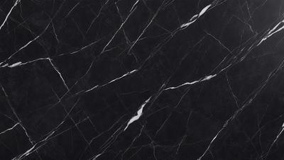 The primary subject of the image is a black marble countertop. The setting is a kitchen, with the countertop being the main focus of the scene. The visual style is a close-up of the marble countertop, showcasing its texture and pattern. The colors and mood of the image are predominantly dark, with the black marble countertop being the main source of contrast.