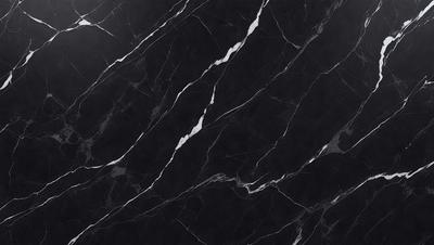 The primary subject of the image is a black marble countertop. The setting is a kitchen, with the countertop being the main focus of the scene. The visual style is a close-up of the marble countertop, showcasing its texture and pattern. The colors and mood of the image are predominantly dark, with the black marble countertop being the main source of contrast.