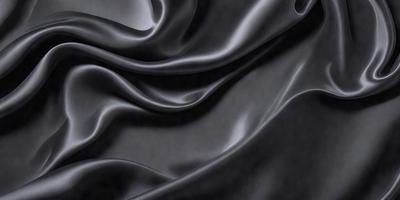 The primary subject of the image is a black fabric, which appears to be a piece of silk. The setting is a black background, which contrasts with the fabric. The visual style is a close-up of the fabric, showcasing its texture and details. The colors and mood of the image are predominantly dark, with the black fabric being the main focus.