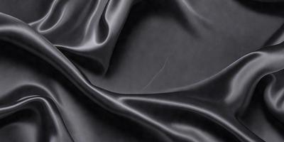 The primary subject of the image is a black fabric, which is the main object, scene, or focus of the image. The setting or background is a dark room, and the visual style is a close-up of the fabric. The colors and mood of the image are predominantly dark and moody, with the black fabric being the dominant color.
