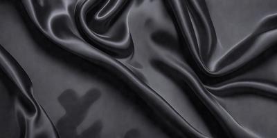 The primary subject of the image is a black fabric, which appears to be a piece of silk. The setting is a black background, and the visual style is a close-up of the fabric. The colors and mood of the image are predominantly dark and moody, with the black fabric being the main focus.