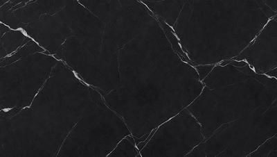 The primary subject of the image is a black marble countertop. The setting is a kitchen, with the countertop being the main focus of the scene. The visual style is a close-up of the marble countertop, showcasing its texture and pattern. The colors and mood of the image are predominantly dark, with the black marble countertop being the main source of contrast.
