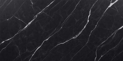 The primary subject of the image is a black marble countertop. The setting is a kitchen, with the countertop being the main focus of the scene. The visual style is a close-up of the marble countertop, showcasing its texture and pattern. The colors and mood of the image are predominantly dark, with the black marble providing a striking contrast against the surrounding environment.